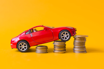 rate increase Red toy car rides up a stack of coins